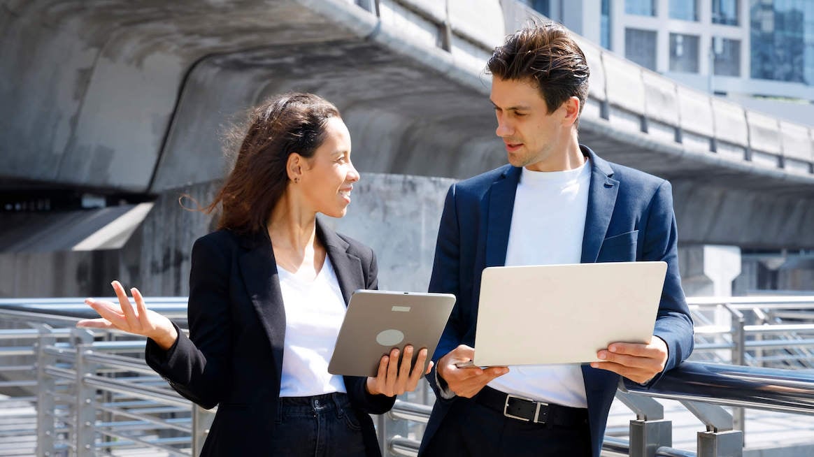 pay-transparency-colleagues-walking-outside-with-tablet