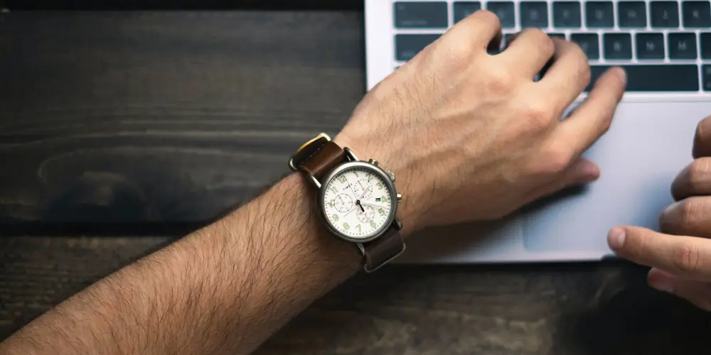 arm-with-a-wristwatch-resting-on-a-laptop-time-management (1)