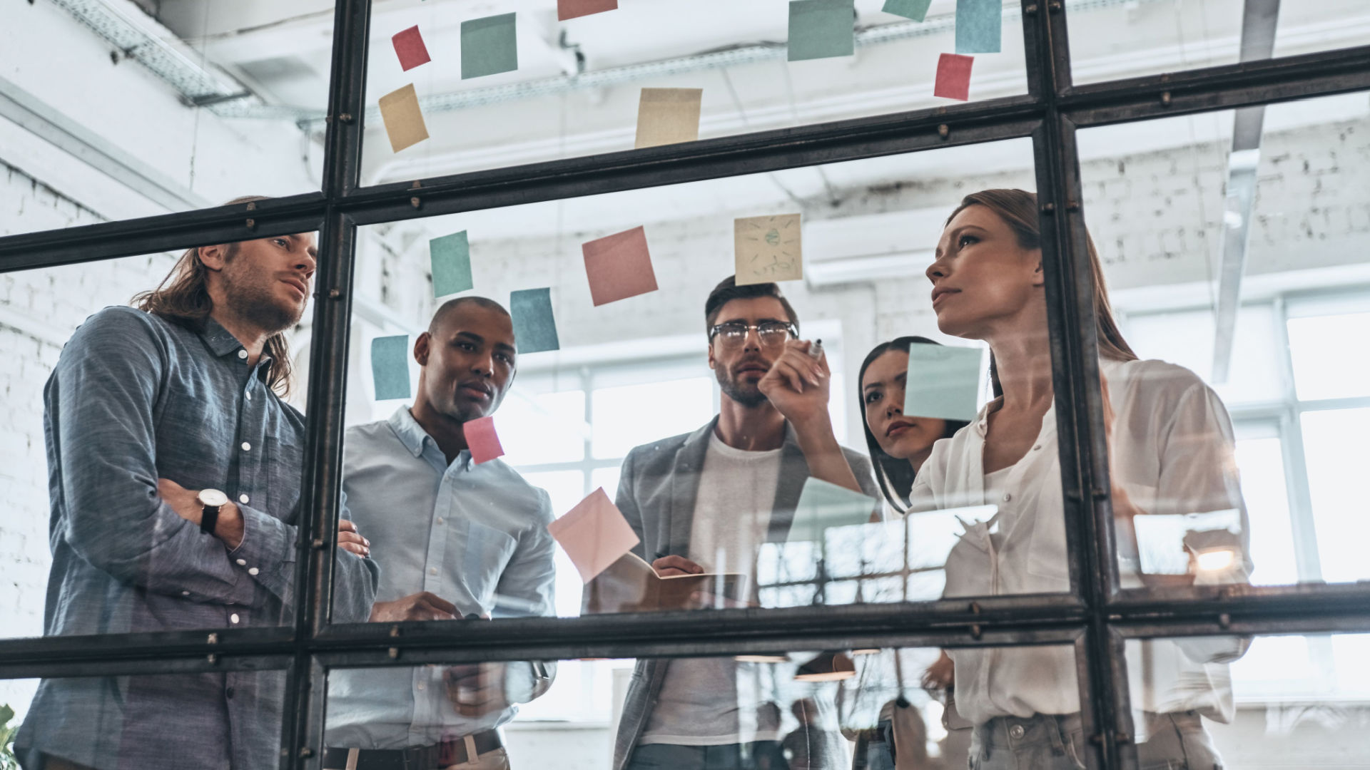 employees-standing-drawing-on-glass-organizational-structure