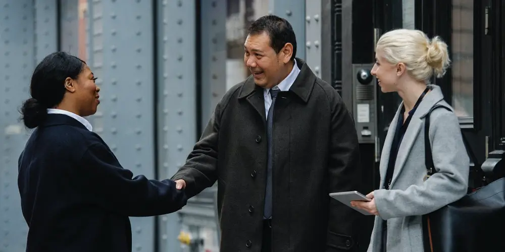 two coworkers shaking hands smiling how to build trust (1)