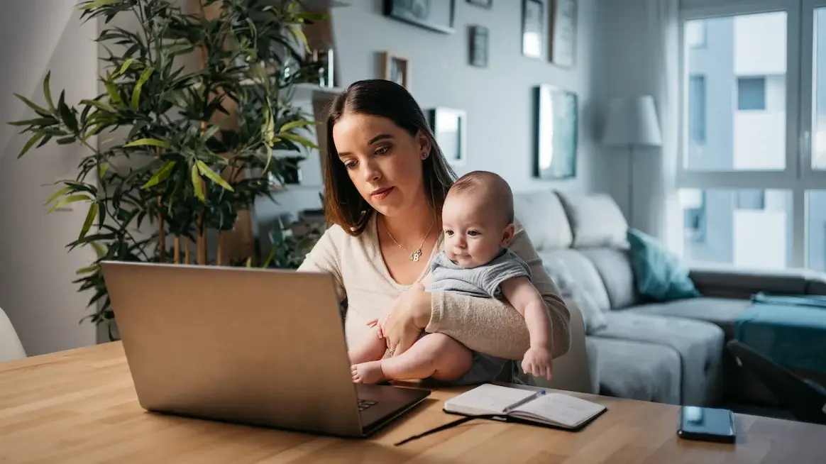 https://9253440.fs1.hubspotusercontent-na1.net/hubfs/9253440/woman%20holding%20baby%20trying%20to%20find%20work%20life%20balance%20(1).webp