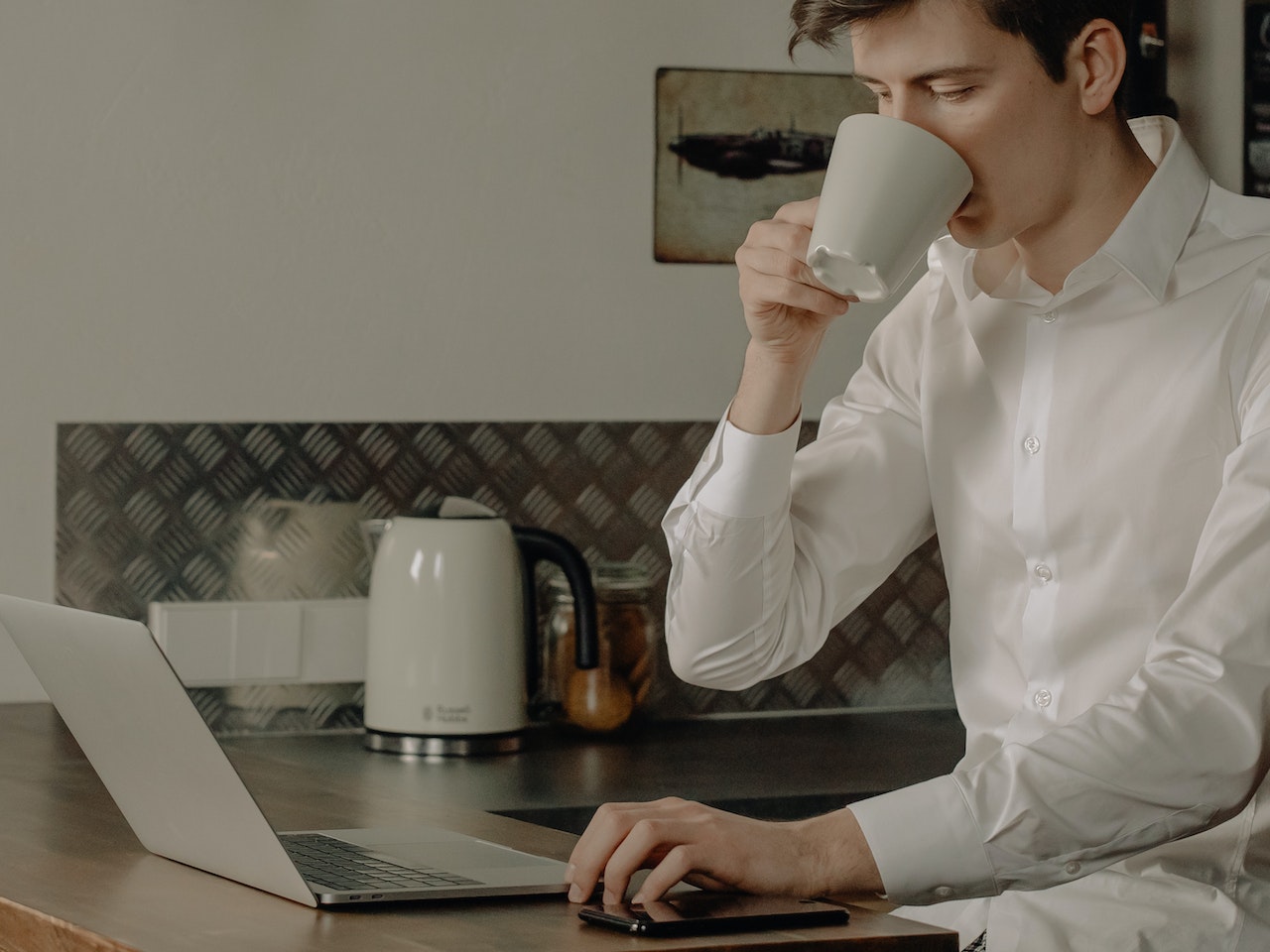 young-man-sitting-in-his-kitchen-drinking-coffee-and-using-laptop-chat-gpt-cover-letter